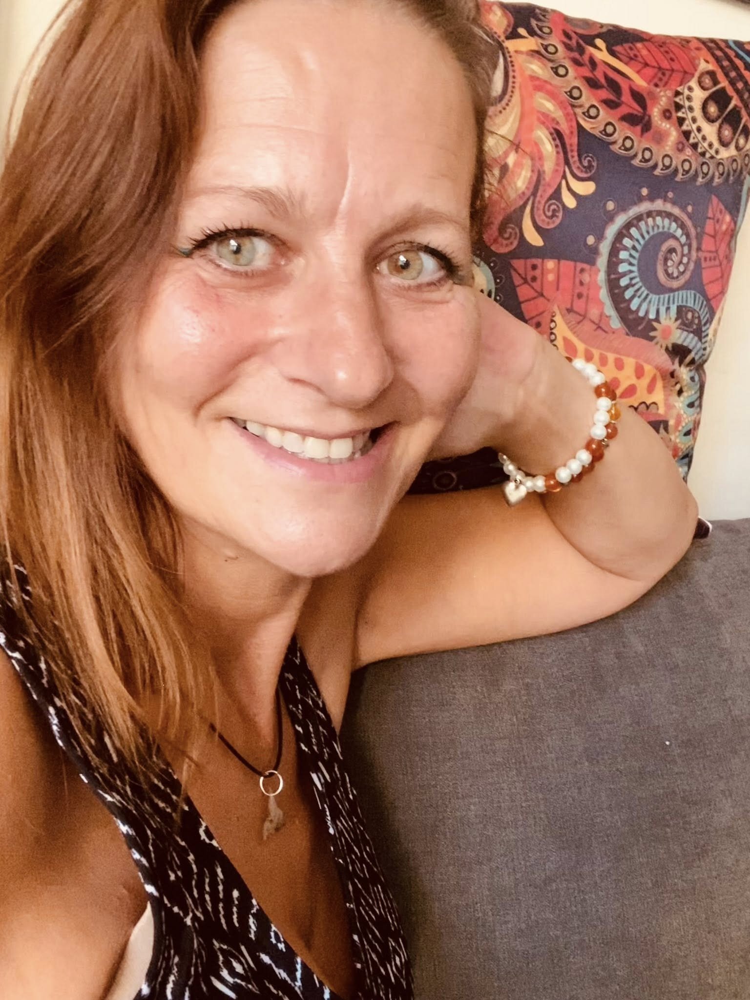 Jessica Dawn Stone smiling warmly, resting her chin on her hand